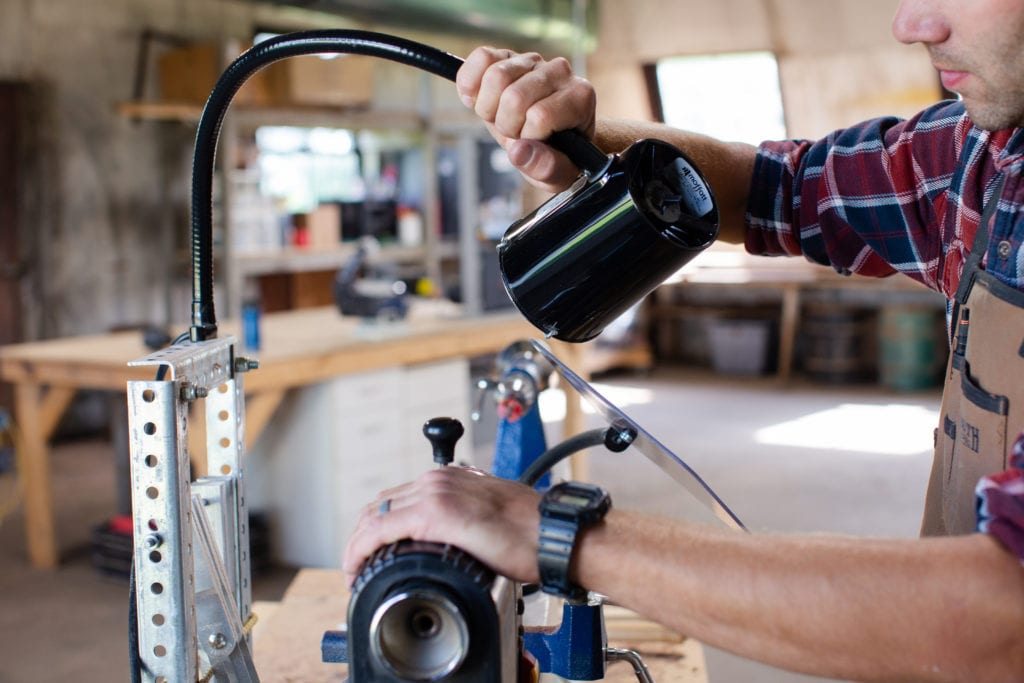 Shop equipment using a protective shield and flex arm lamp