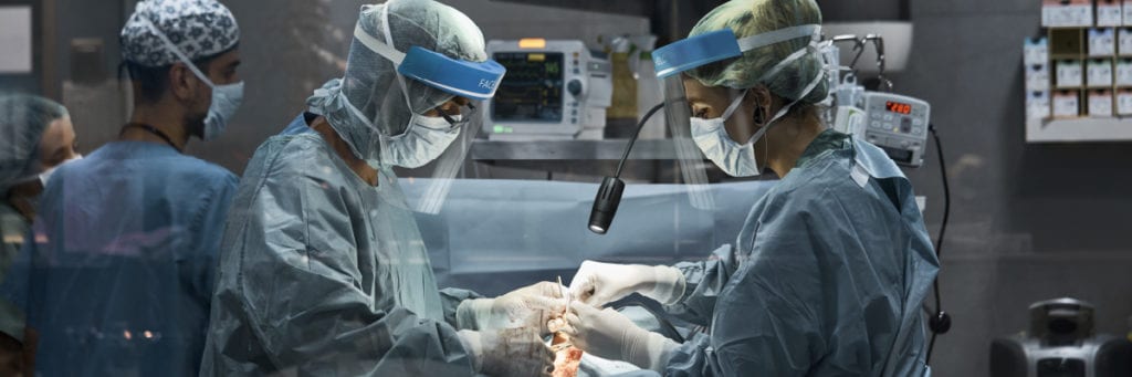 Physicians Performing Surgery on Patient with a Flex Arm Lamp